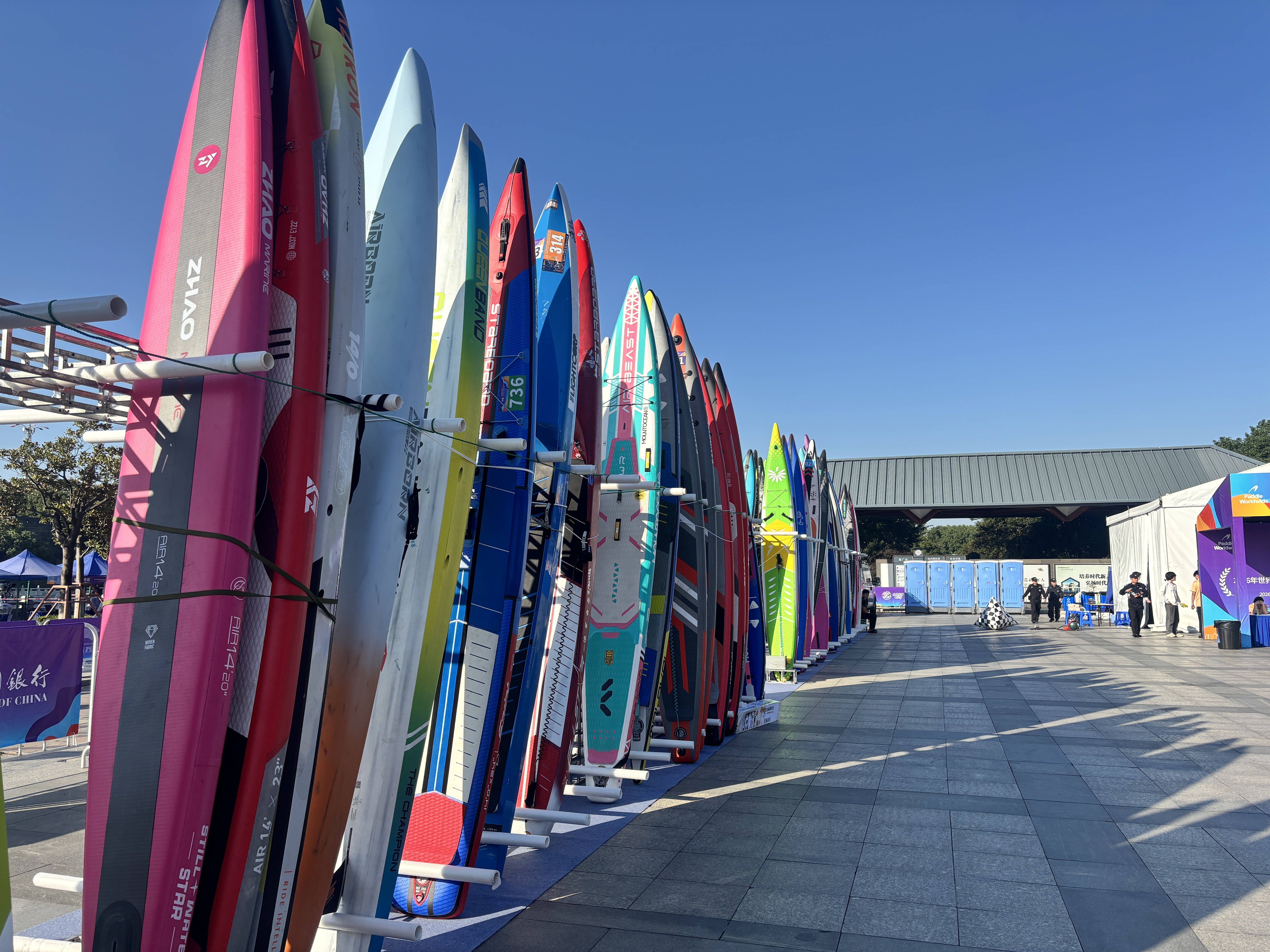Colourful SUP boards standing side by side in the storage area