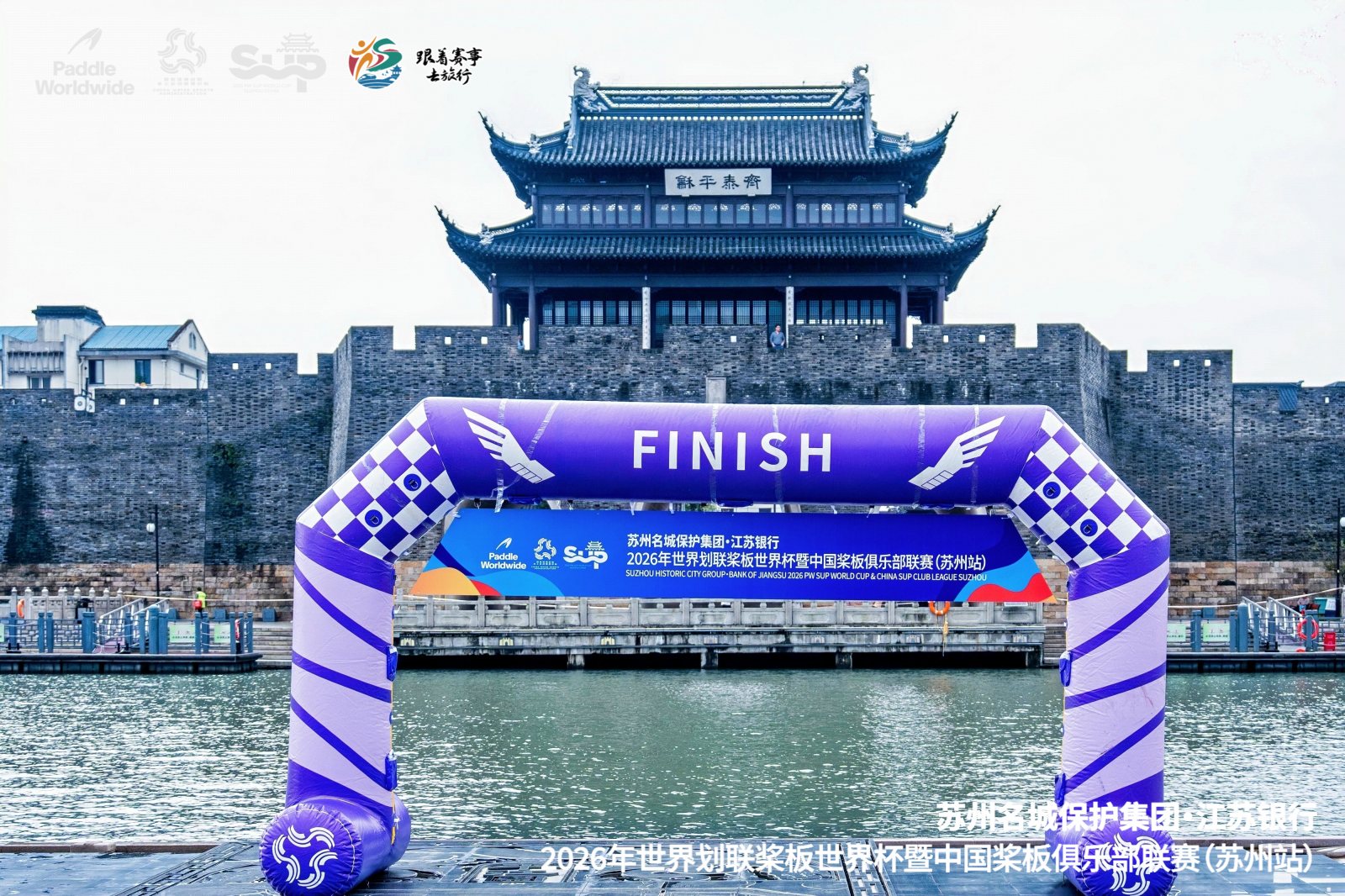The purple finish arch on the water in front of old-city architecture