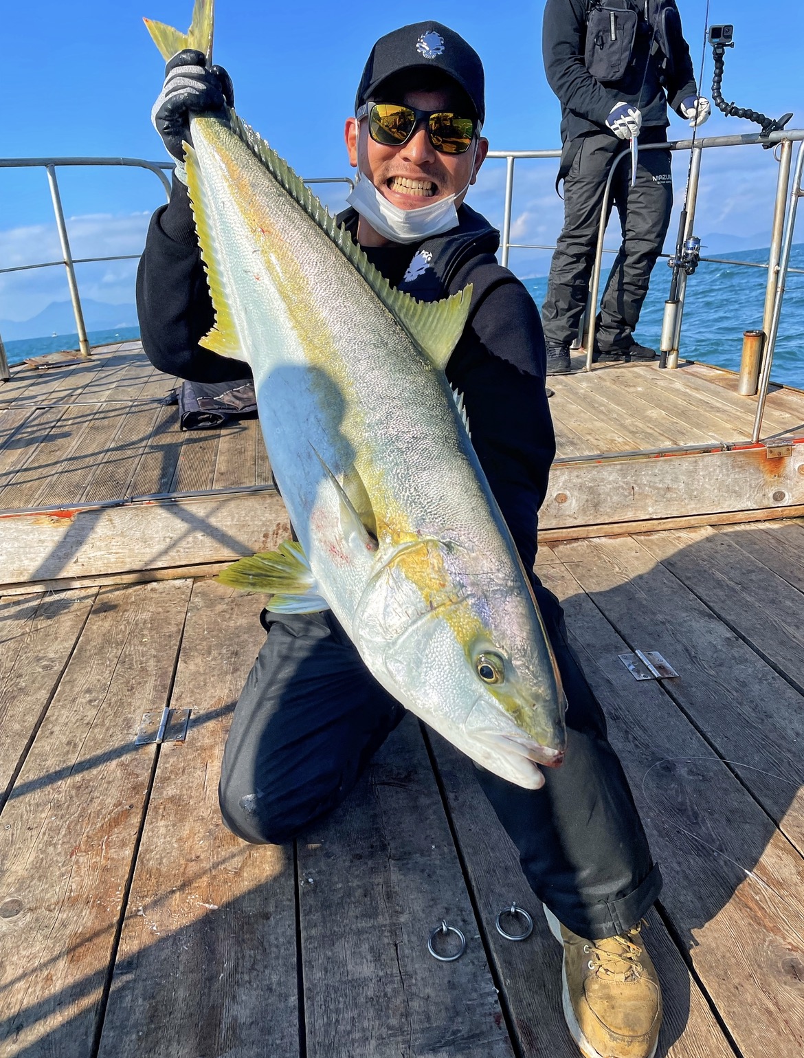Ahn Sugon holding a large fish on a boat