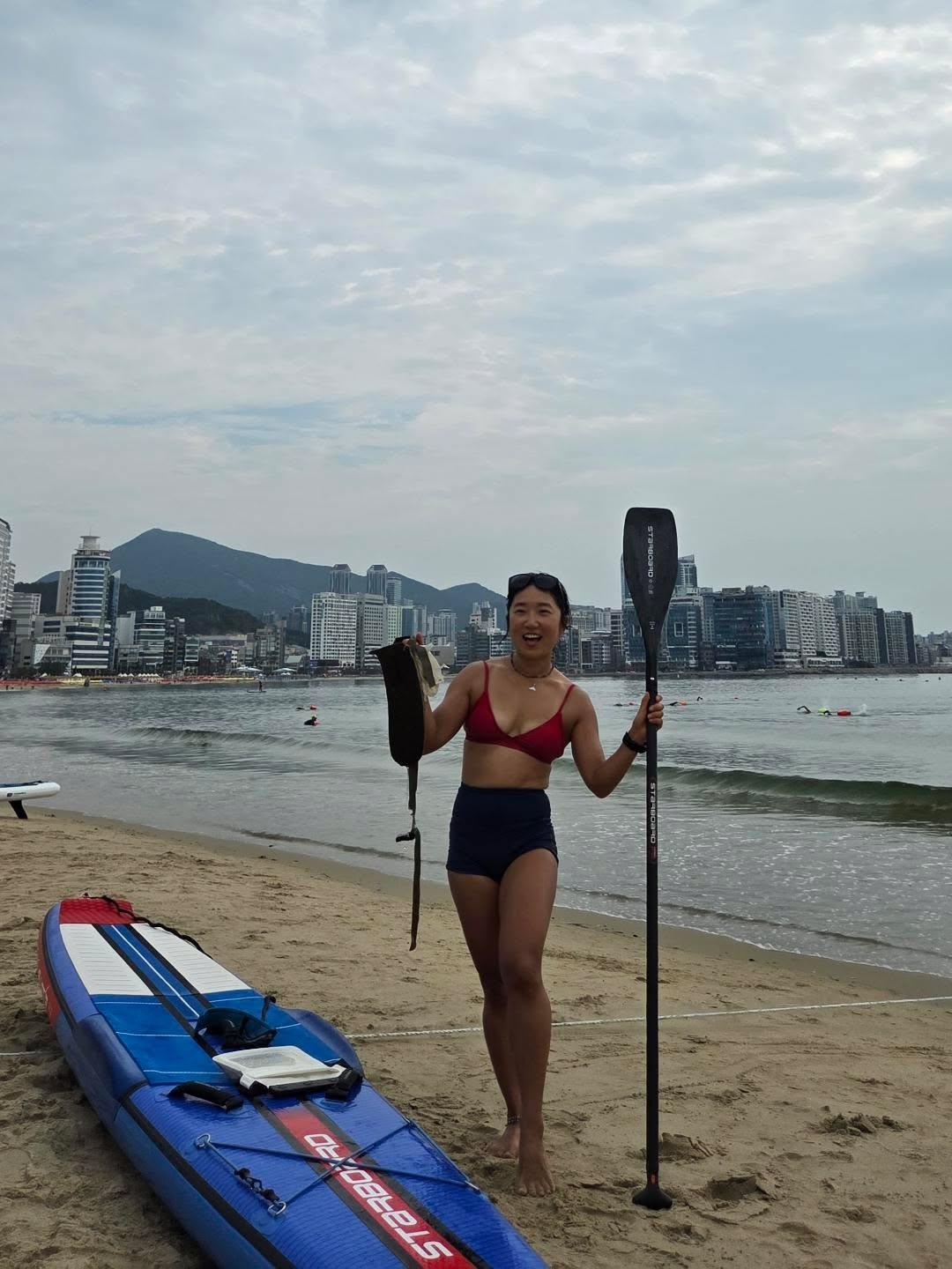Bae Soyeong (Haebom) with a paddle and board on the beach